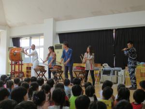 夏祭りで太鼓の演奏を聞いている子供たちの写真