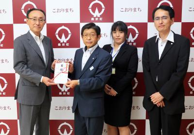 (写真)大木理事長から高橋町長へ寄附目録が手渡される様子