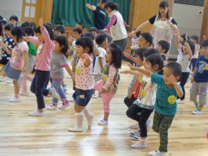 先生の動きを真似して踊っている子供たちの写真