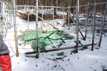 鉄条網に囲まれシートに包まれた簡易水道の水源地の写真2