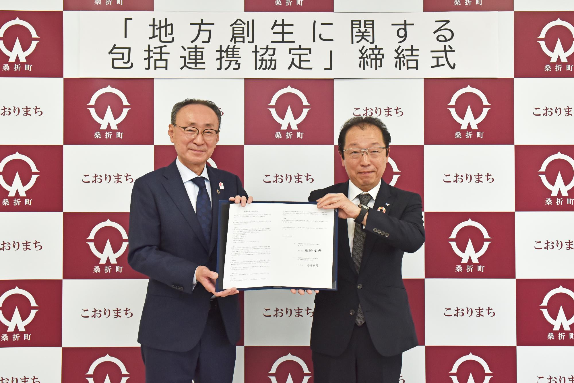 協定書を手にする（左から）高橋町長、佐川急便株式会社南東北支店の小平支店長の写真