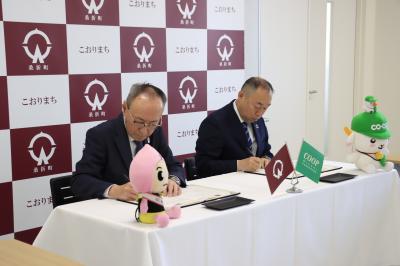 協定書に署名する高橋町長と尾川代表理事